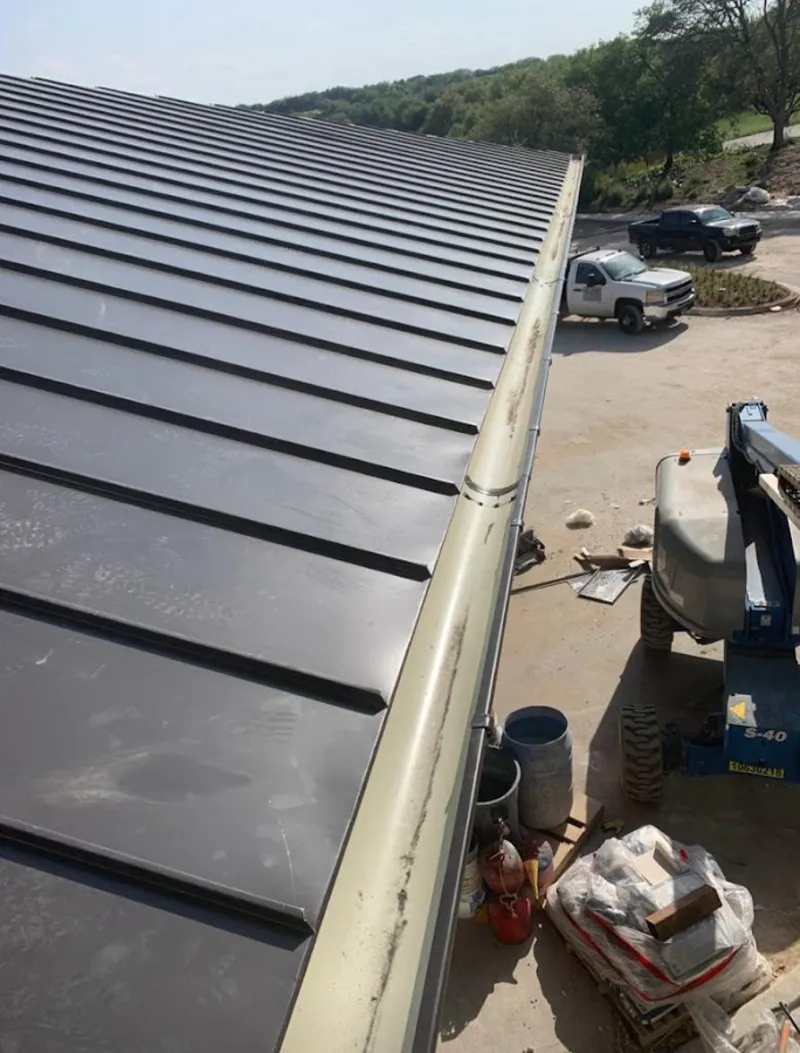 Standing seam panel and gutter detail on a metal roofing jobsite in Pavilion